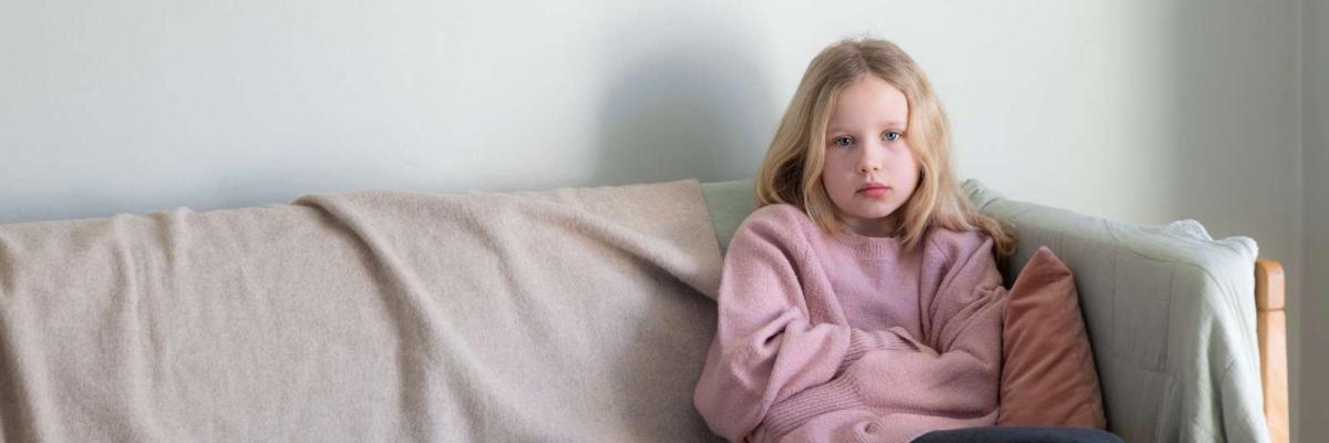 Pige sidder i sofa