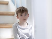 Dreng sidder på trappe