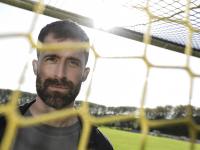 Portrætbillede af Martin Mikkelsen taget gennem et fodboldnet