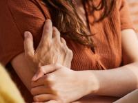 Billede af hånd der ligger betryggende på arm