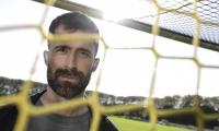 Portrætbillede af Martin Mikkelsen taget gennem et fodboldnet