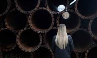 Billede af pige set bagfra stående foran stålrør