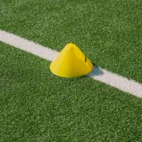 Gul kegle på optegnet streg på fodboldbane