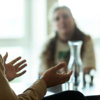 Mand taler og gestikulerer med hænderne til kvinde