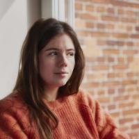 Kvinde, sidder ved vindue