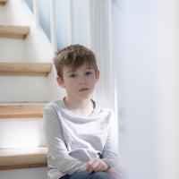 Dreng sidder på trappe