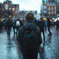 Person, set bagfra, står alene